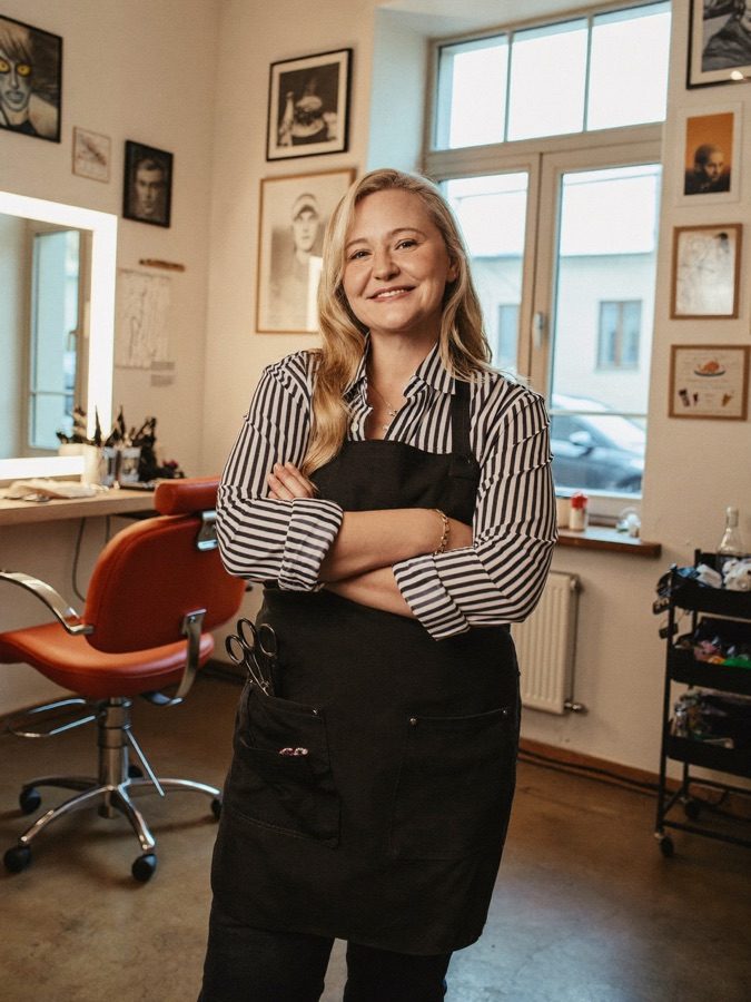 Uśmiechnięta fryzjerka w swoim jasnym salonie